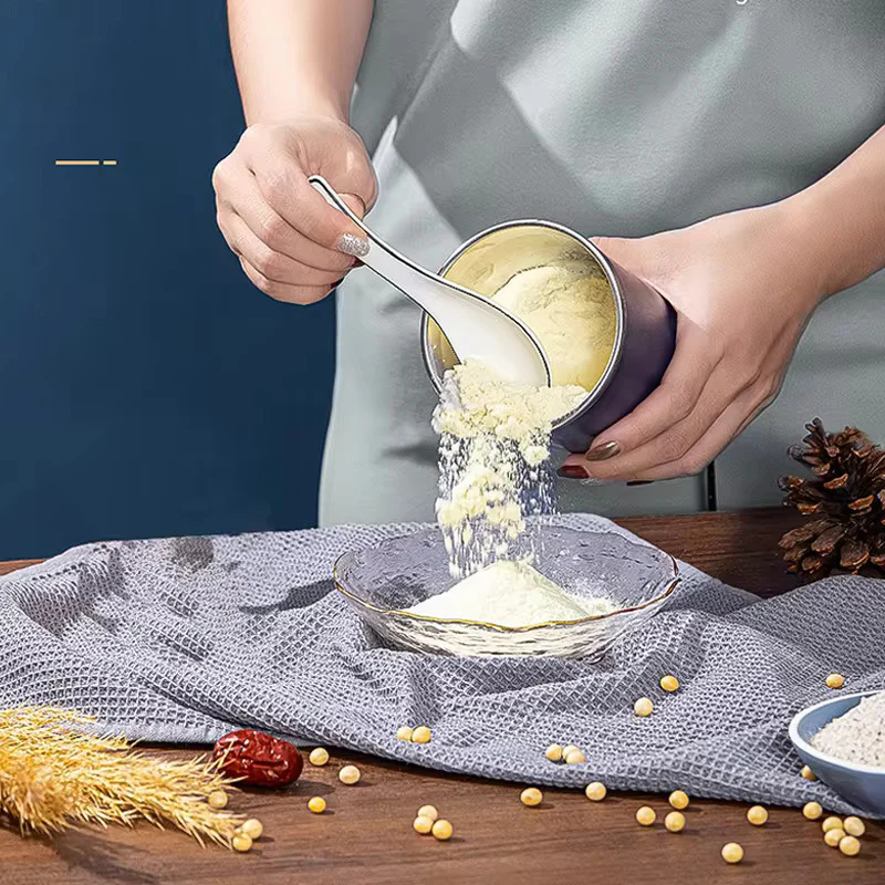 Person using a grinder to pour finely ground powder into a glass bowl, showcasing the machine's efficiency in producing smooth, powdered results from solid ingredients.